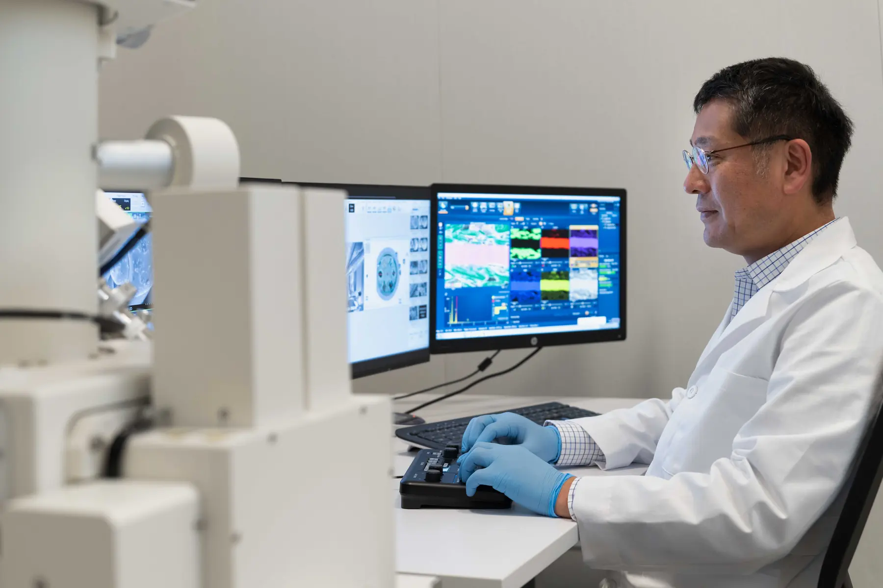 Scientist reviewing AMICS mineral maps at a Hitachi scanning electron microscope
